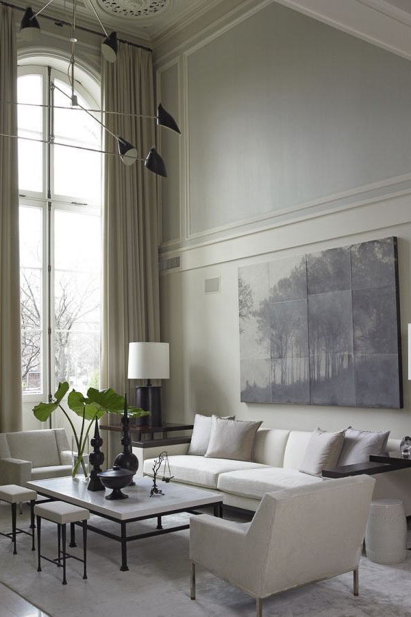 Two story wall with large art and floor to ceiling curtains.