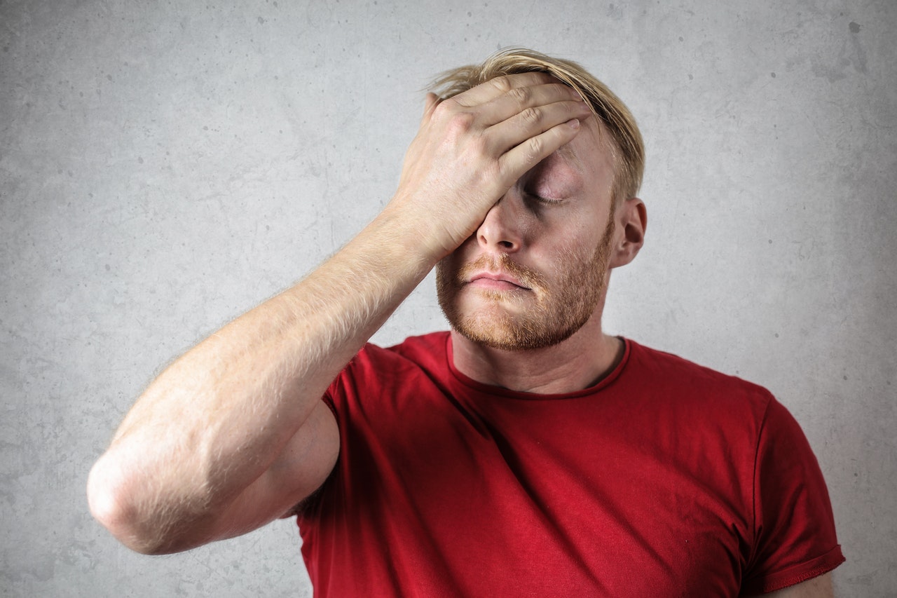 Man holding his hand to forehead looking worried and upset