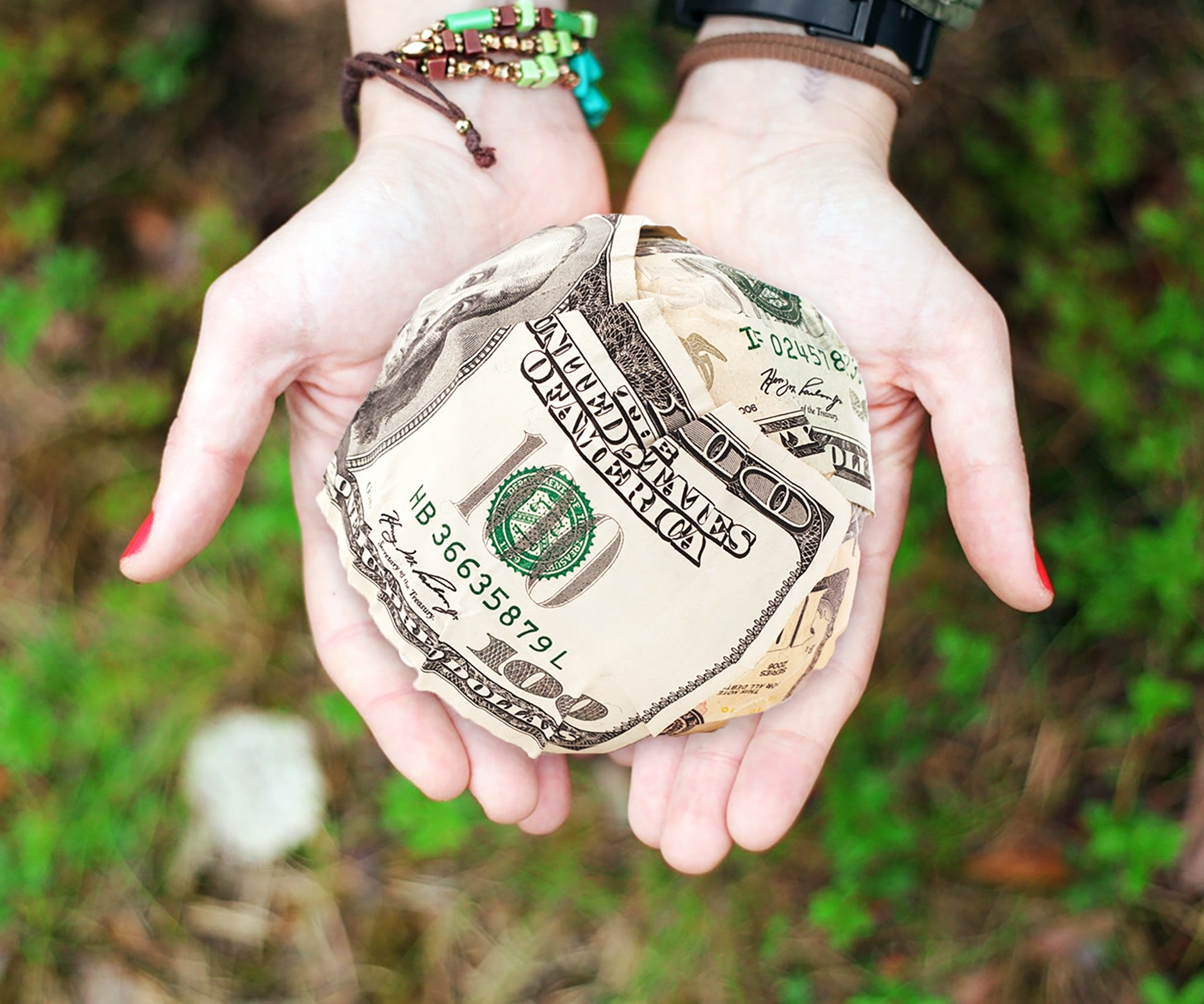 creative women holding saved money in a ball.