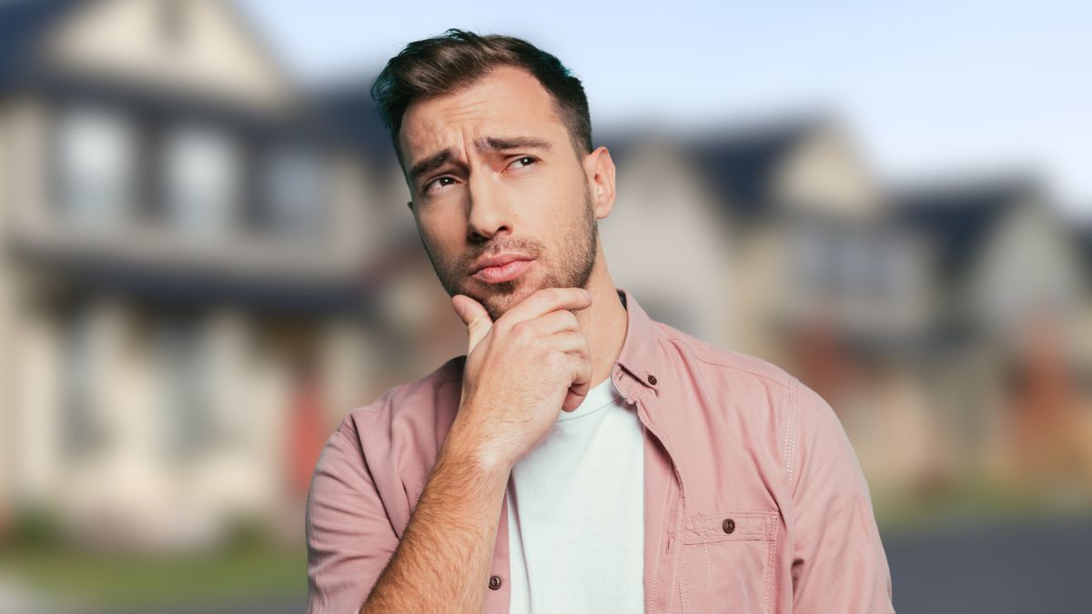 man thinking in front of houses