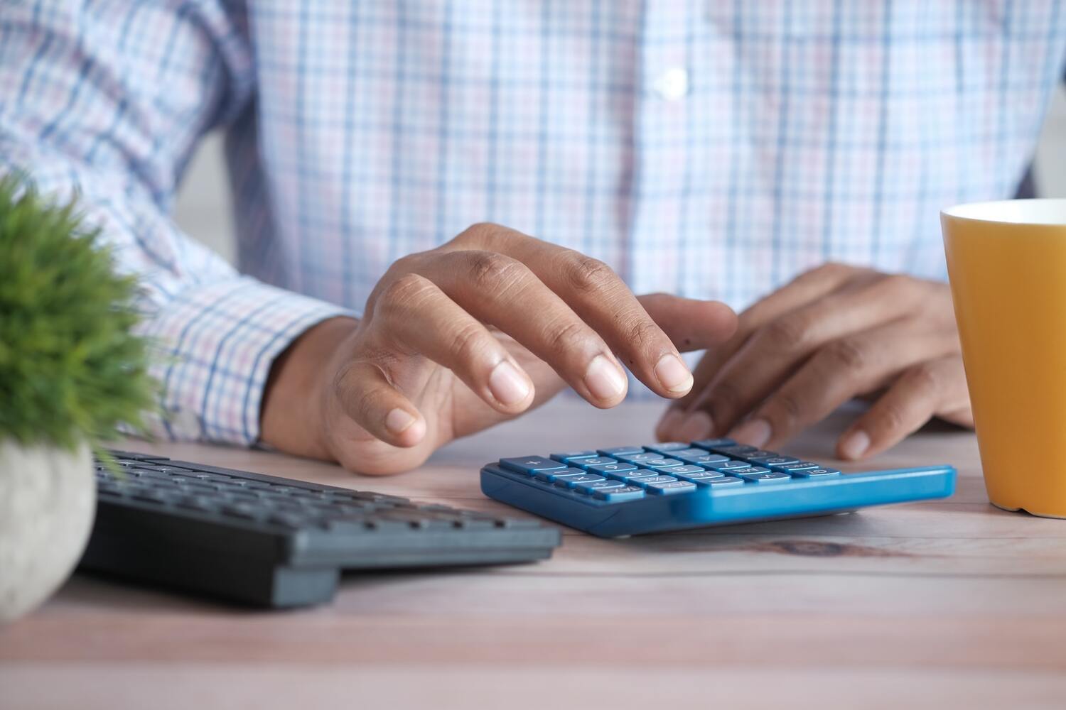 Man using a calculor to figure how to lower student loan payments.