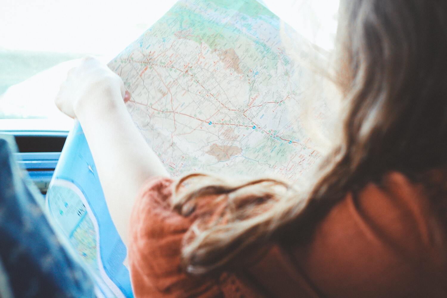 A girl looking at a map for a road trip.