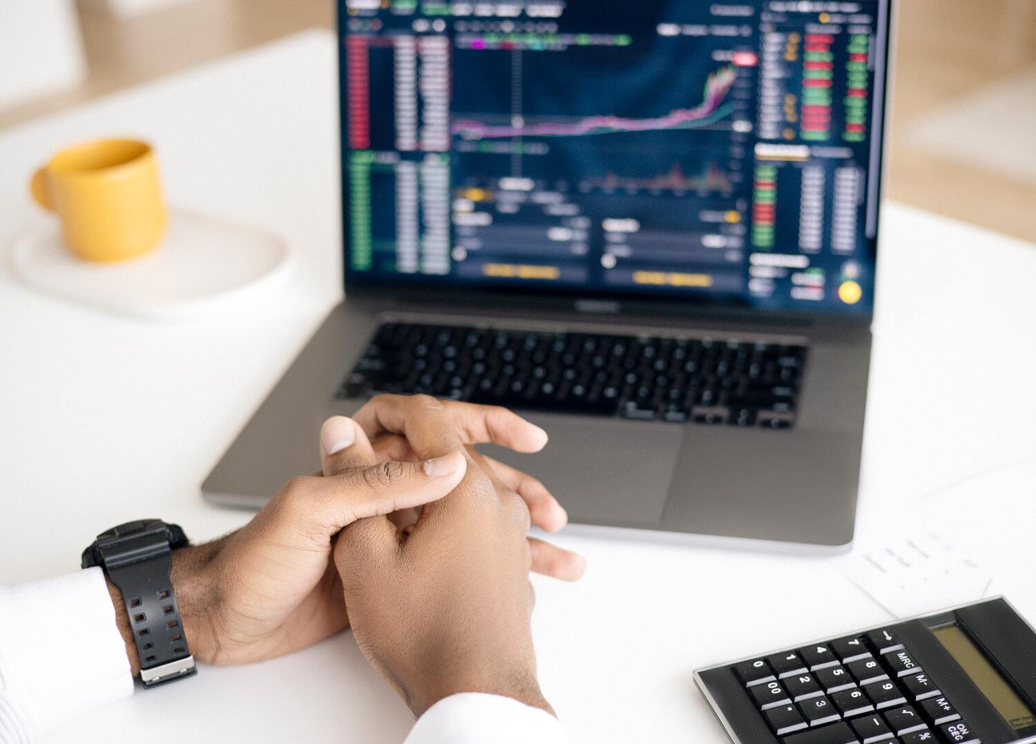 A man looking at a screen of stock market returns.