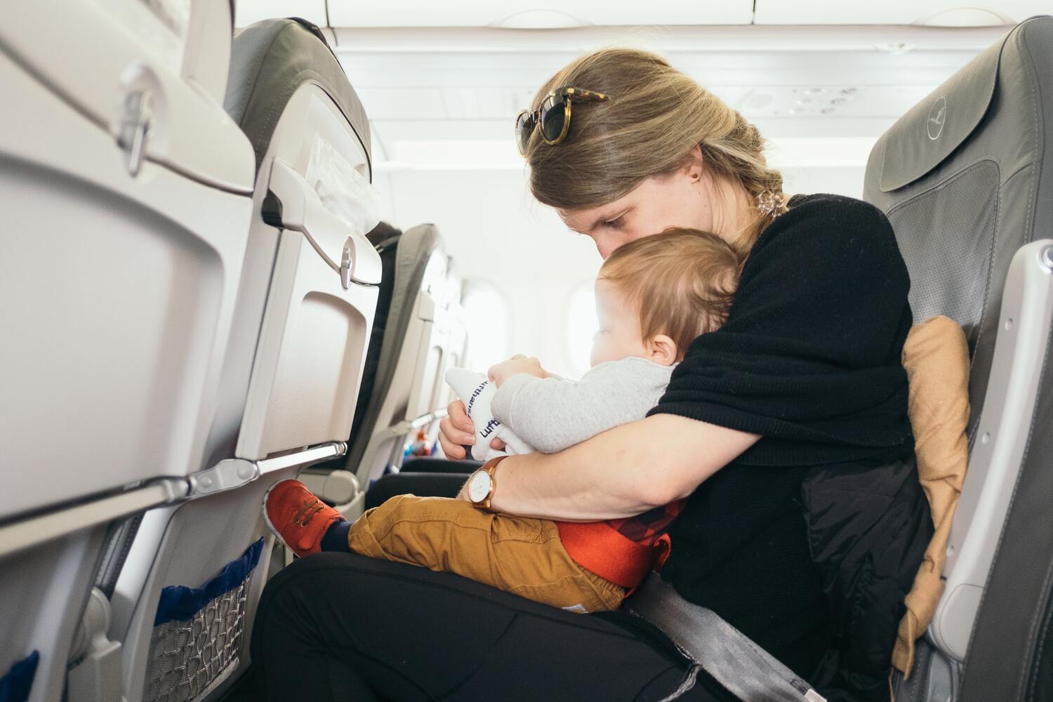 A Mom on a plane traveling with a baby.