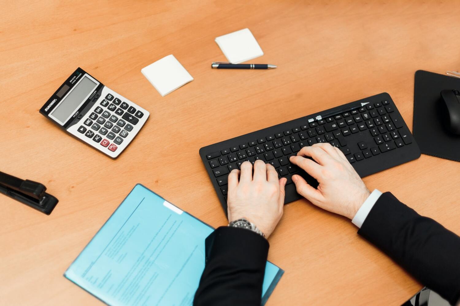 A person using a prorated rent calculator on a desk.