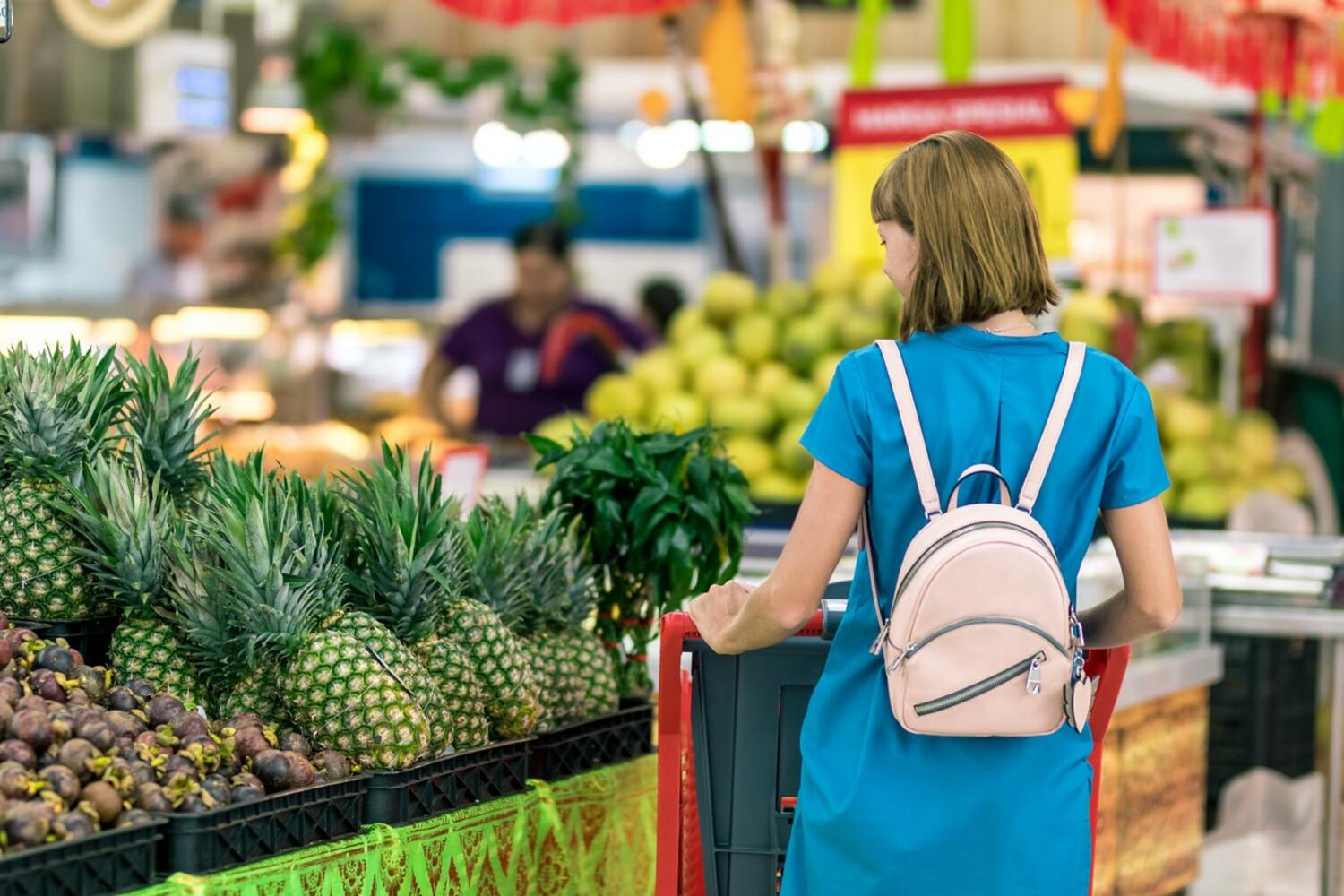 A women shopping in a store and saving on her grocery bill.