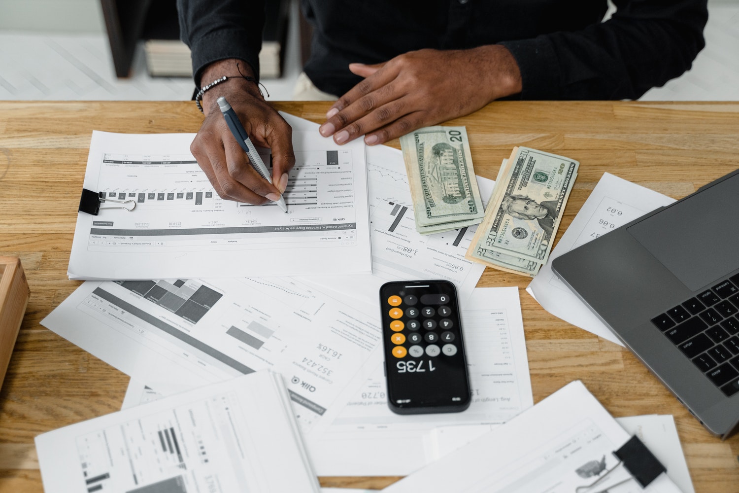 Papers on a desk and a man trying to get out of debt.
