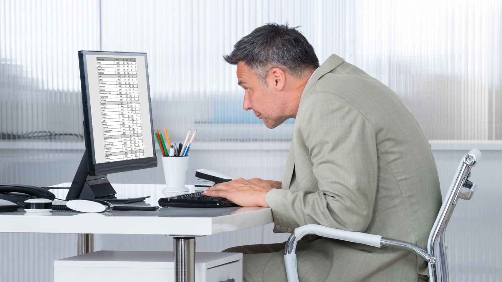 businessman working at a desk with bad posture