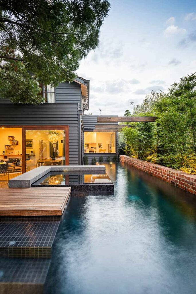 Modern home with dark blue tile pool.
