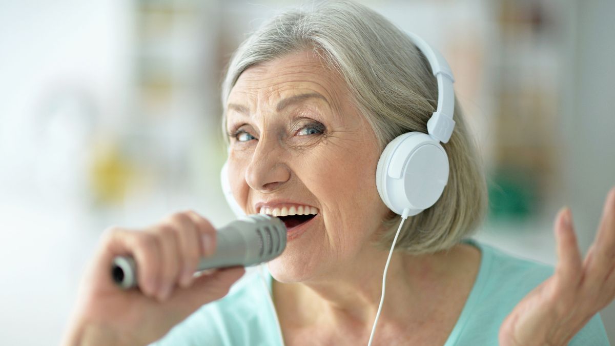 old woman singing with headphones