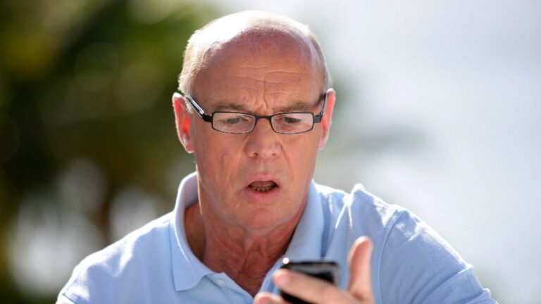 Shocked old man reading text message