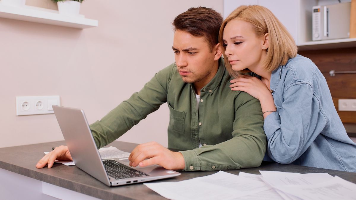 couple looking at laptop and documents