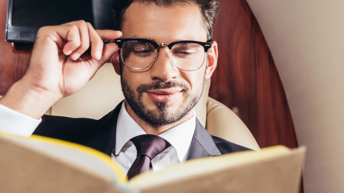 man with glasses reading a book