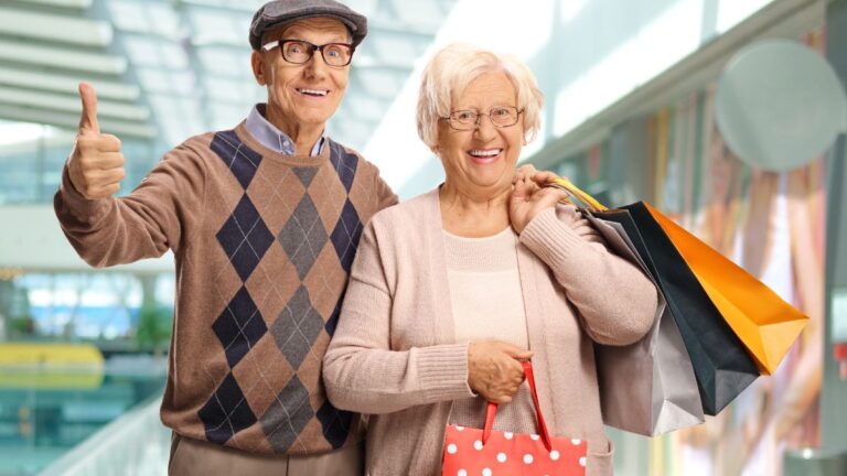 Happy elderly people shopping in a mal