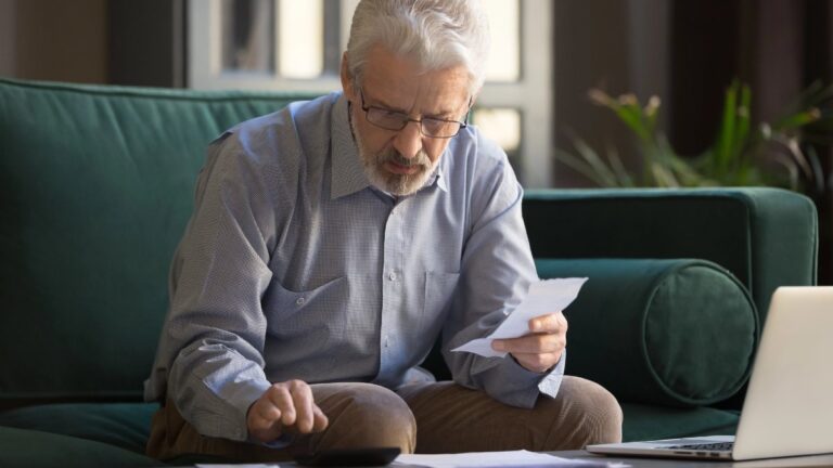 Mature man holding receipt