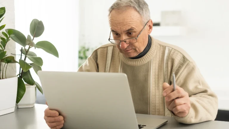 Busy smart mature professional man using laptop sitting.