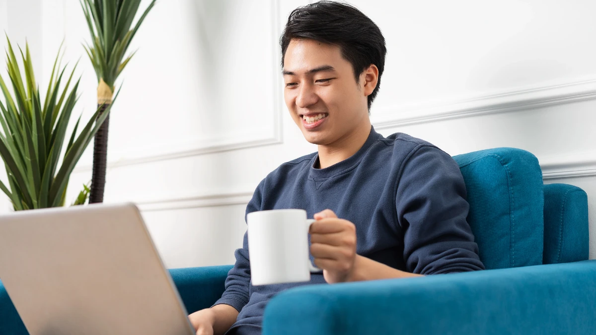 Portrait of asian man sitting on sofa at home