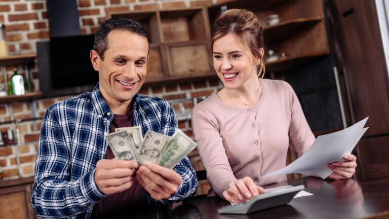 Portrait of happy couple counting money together at