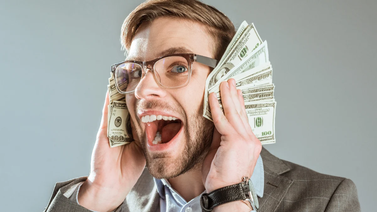 Rich happy businessman holding dollar bills near