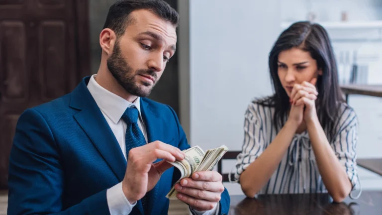 Woman with clenched hands looking at collector counting