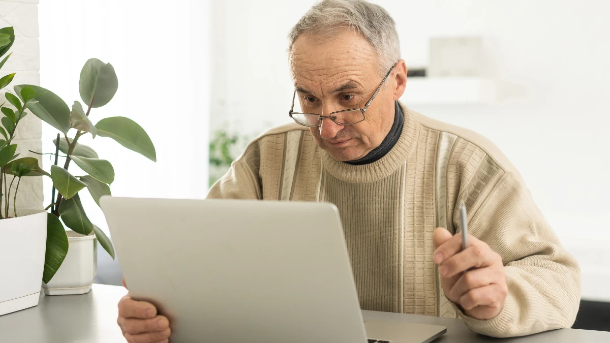 Busy smart mature professional man using laptop sitting