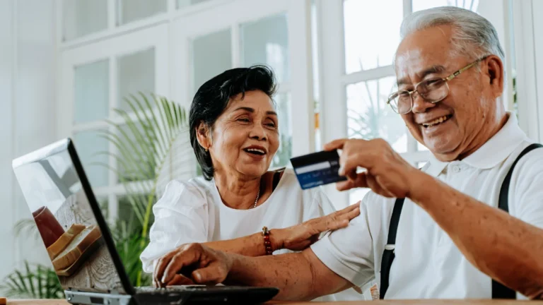 Happy Asian couple shopping online together