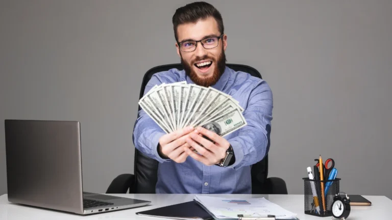 Happy bearded elegant man in eyeglasses showing money