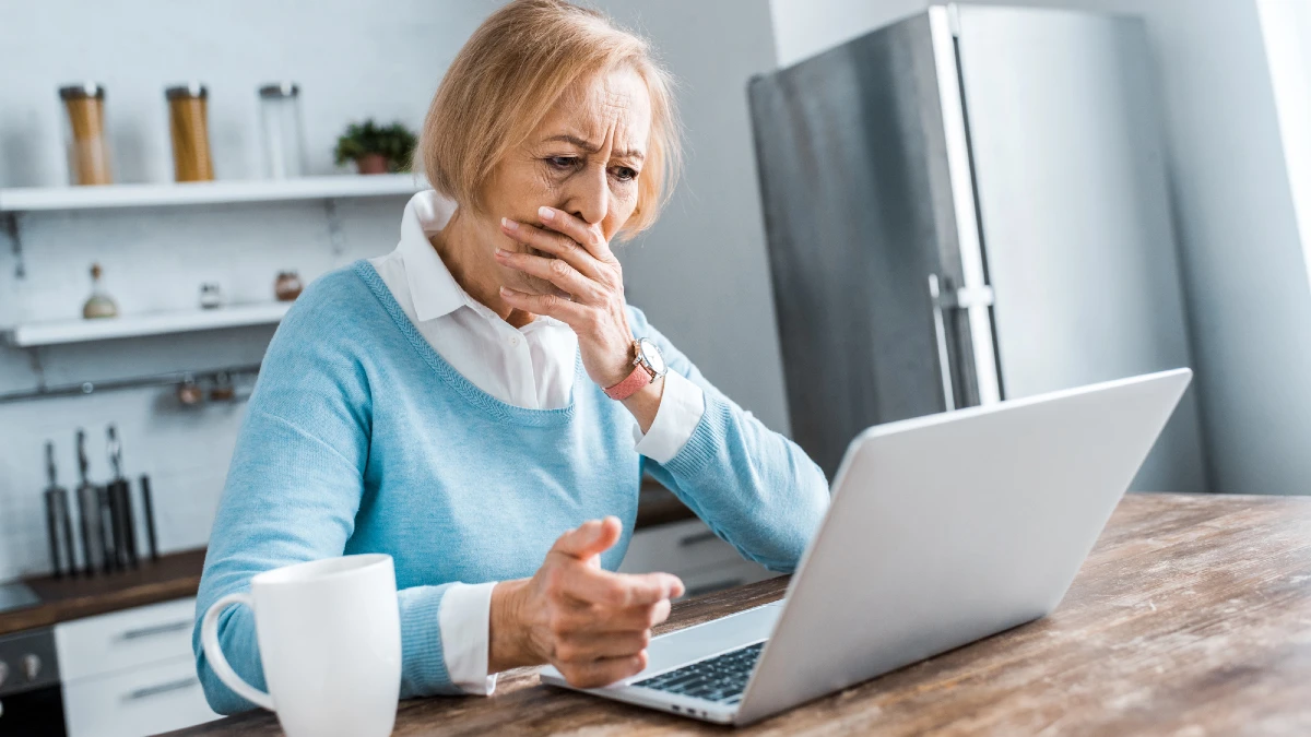 Upset senior woman covering mouth with hand