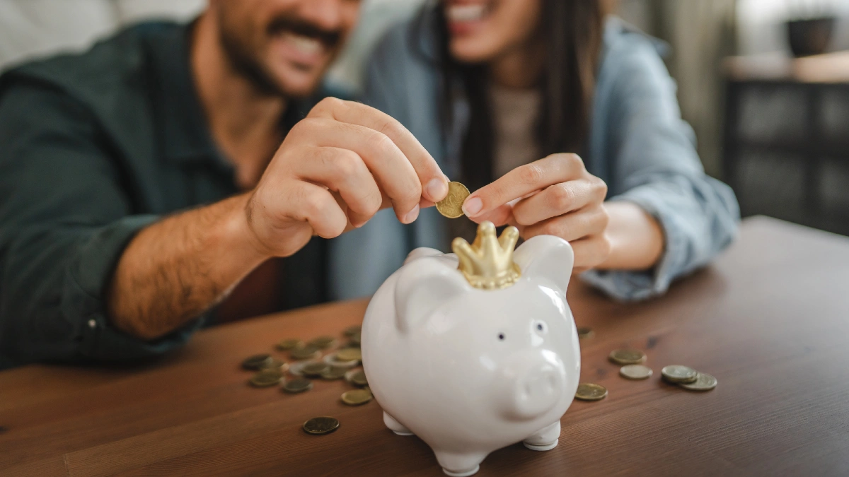 Adult couple save money coins in the piggy bank at home