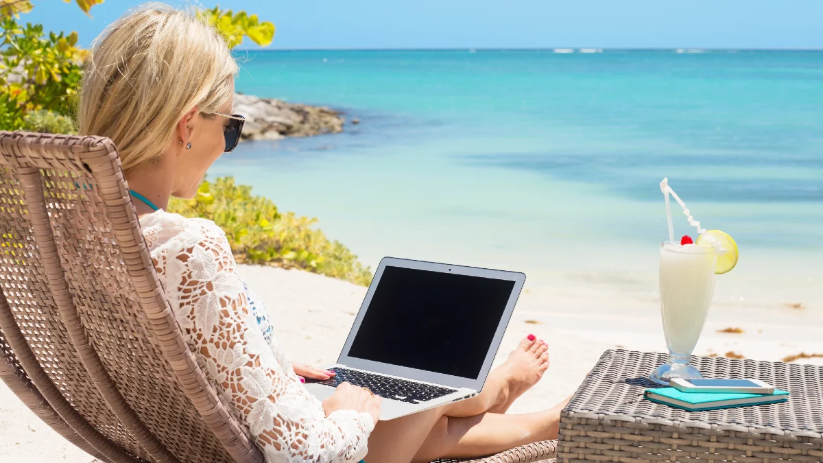 Business woman working with computer on the beach