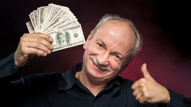 Elderly man showing fan of money