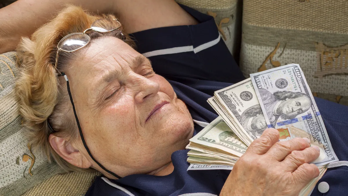 Woman pensioner sleeping with money in her hand