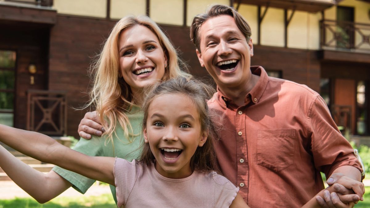 Family smiling outside their house